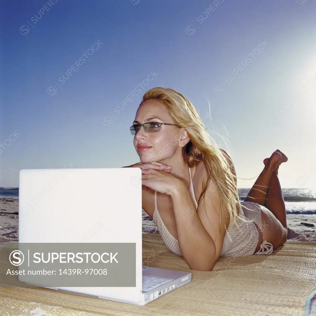 Woman with laptop computer on beach