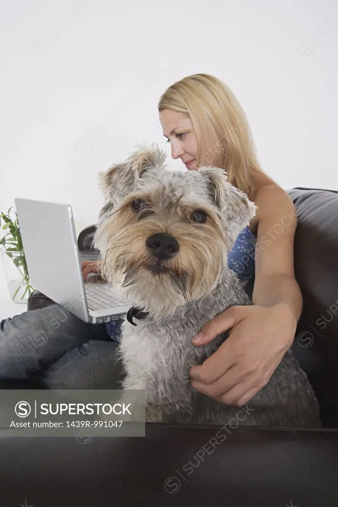 Woman with laptop and pet dog