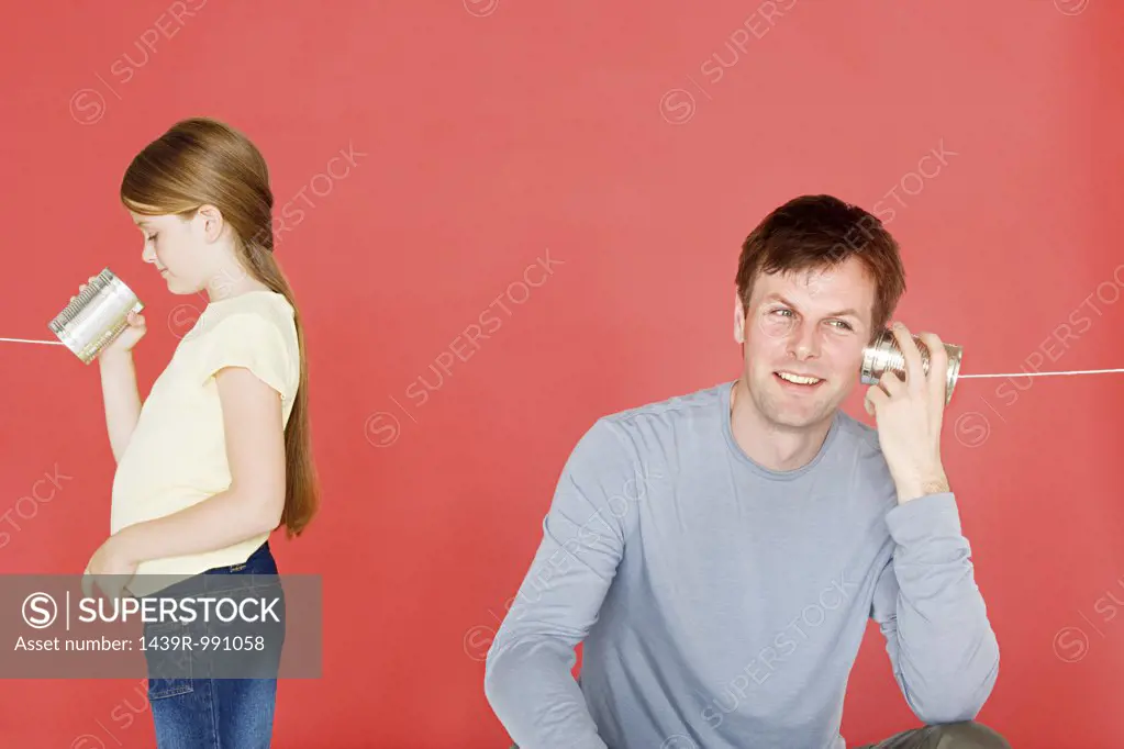 Father and daughter with tin can phone