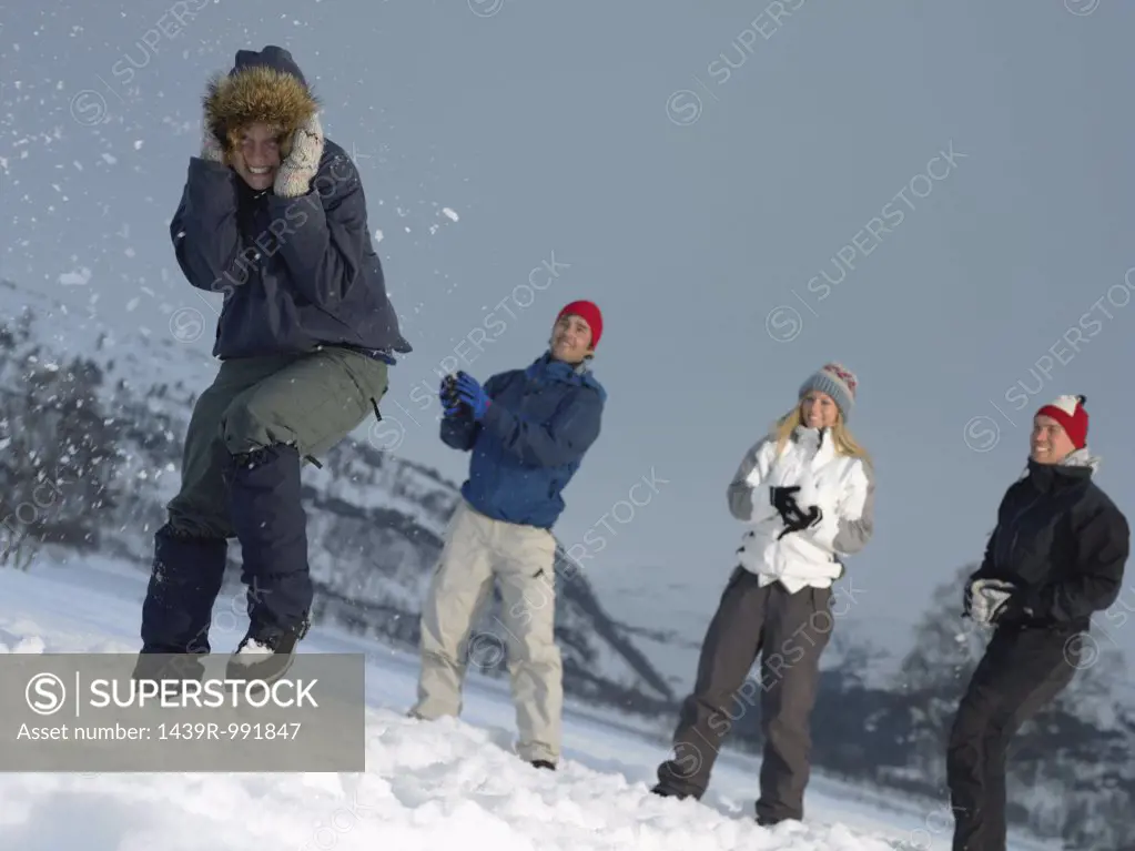 Friends throwing snowballs