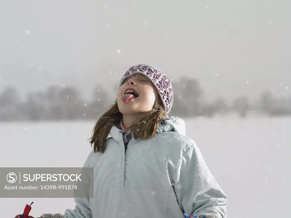Girl catching snow on her tongue