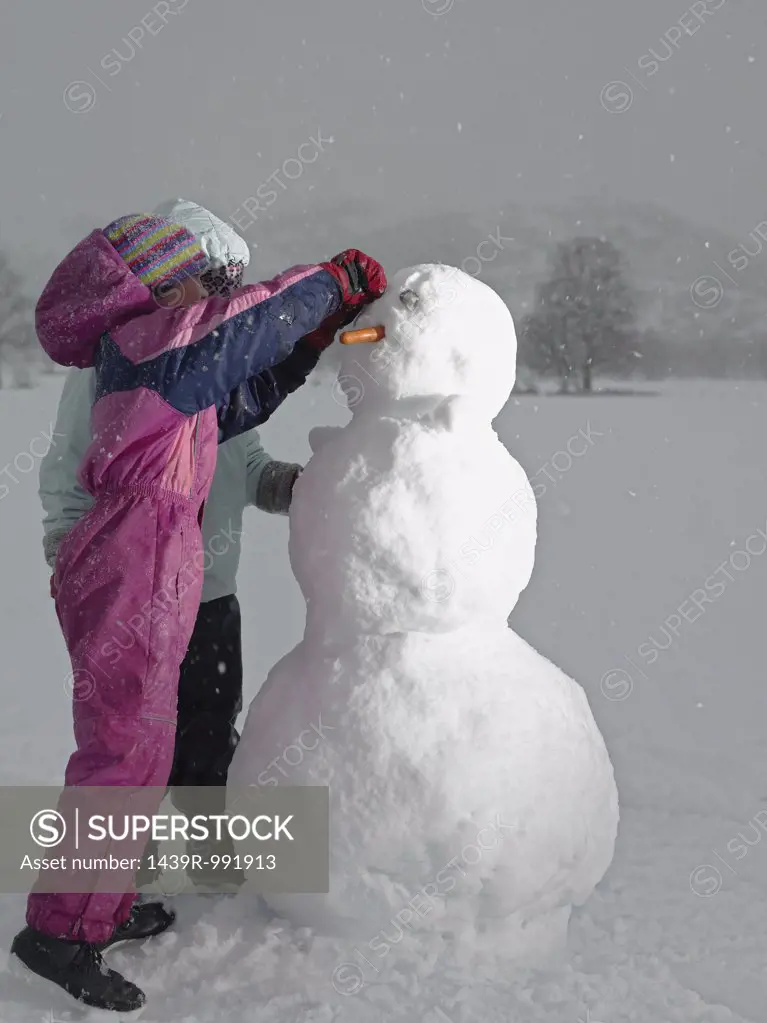 Girls making a snowman