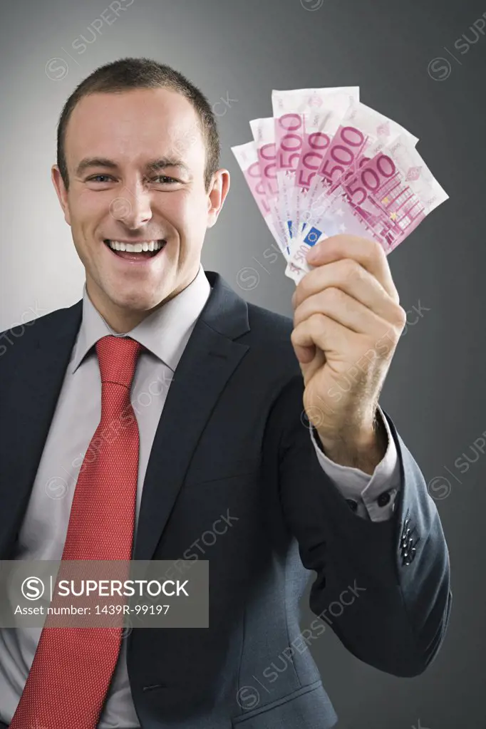 Smiling businessman with bank notes