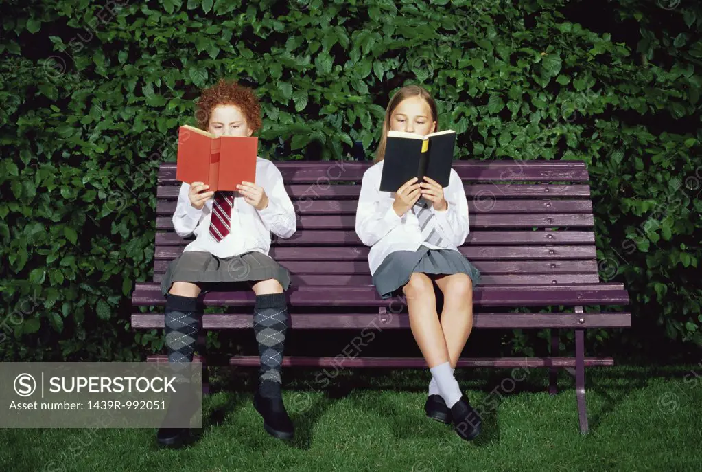 Schoolgirls reading on a bench