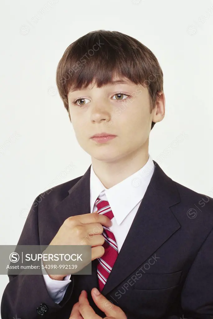Schoolboy adjusting his tie