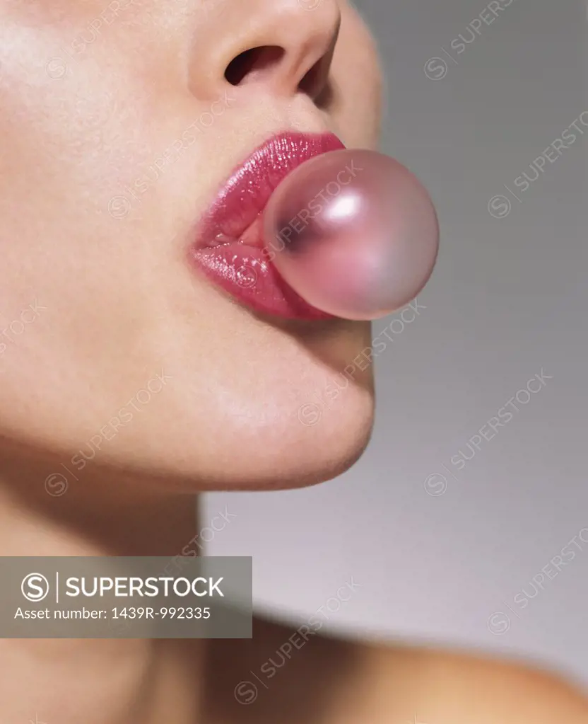 Woman blowing a bubble gum bubble