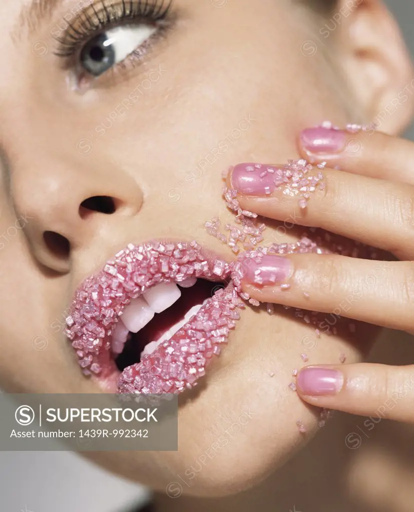 Woman with pink sugar crystals on her lips