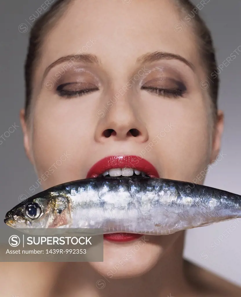 Woman with fish in her mouth