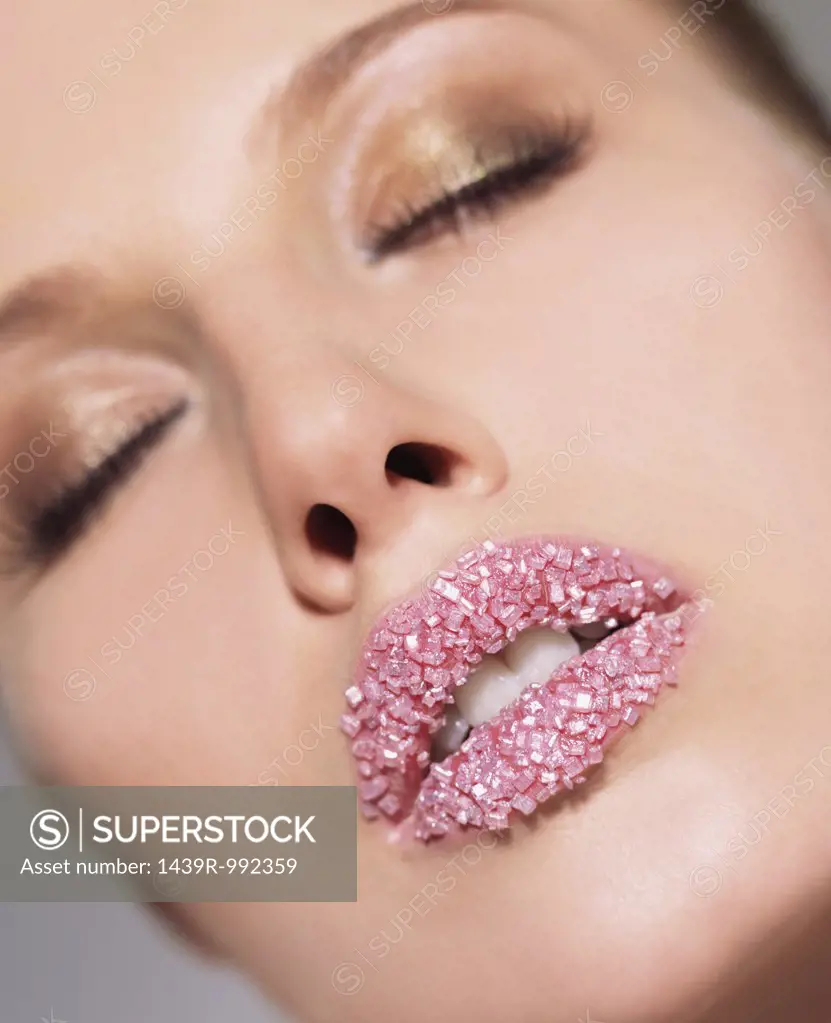 Woman with pink sugar crystals on her lips