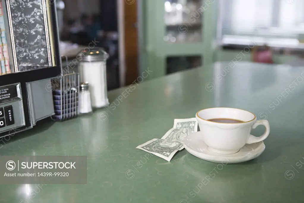 Coffee and money on a diner counter