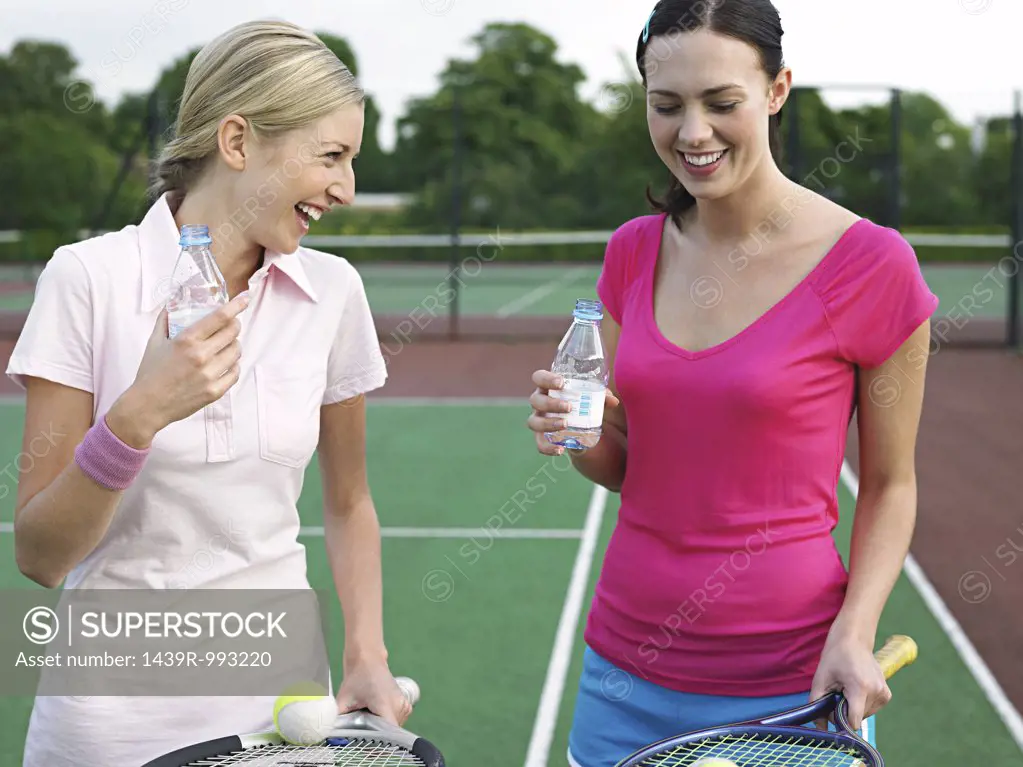 Women having fun on tennis court