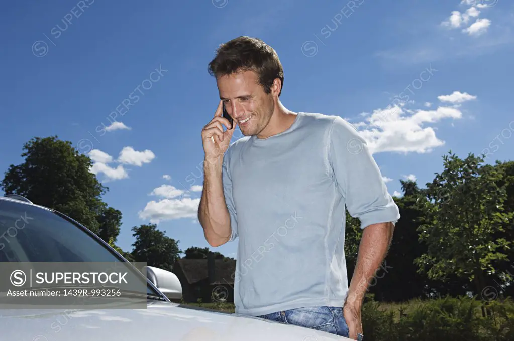 Man in mobile phone by his car