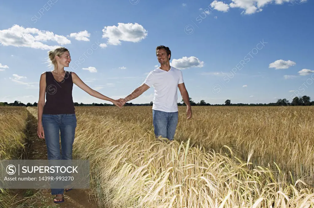 Couple holding hands in a field