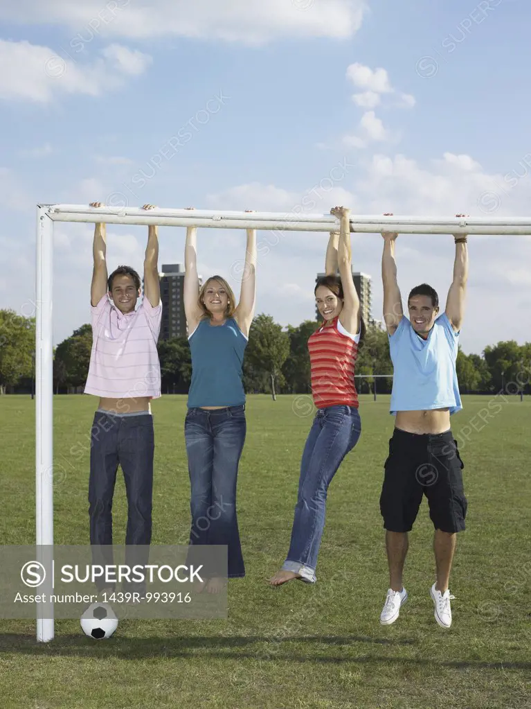 People hanging from a goal post