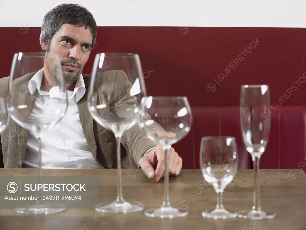 Man sitting at table with wine glasses