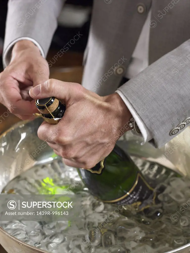 Man opening champagne bottle