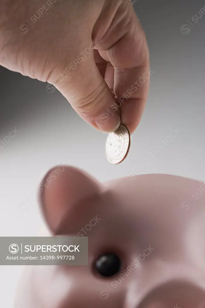 Putting money in piggy bank