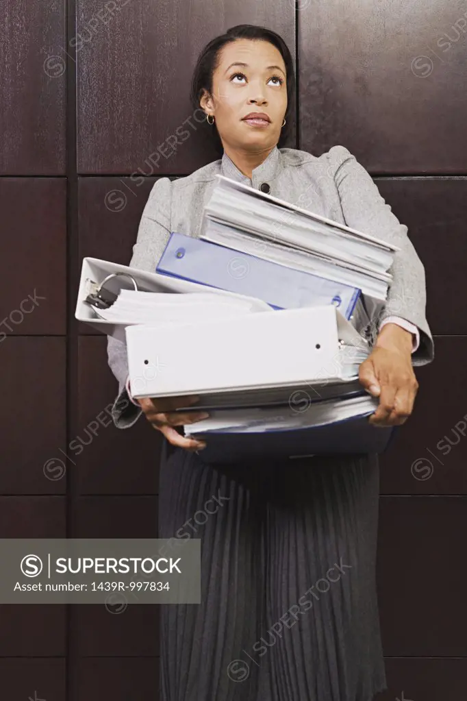 Businesswoman struggling with heavy files