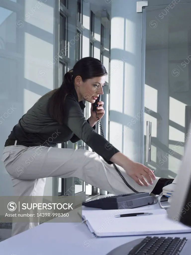 Woman on the telephone and stretching
