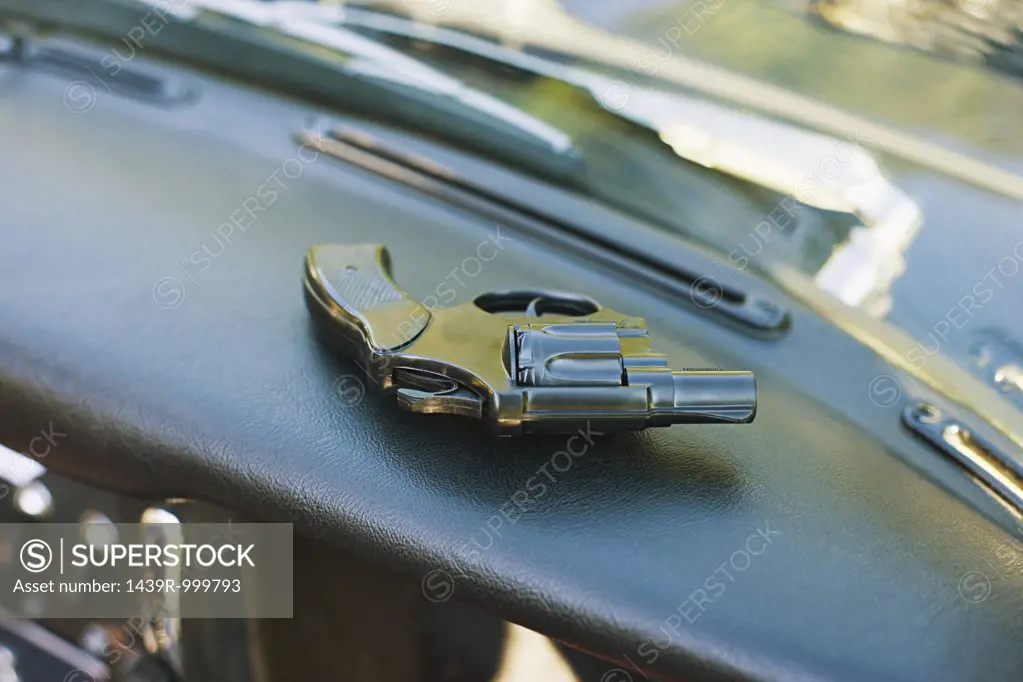 Handgun on dashboard of car
