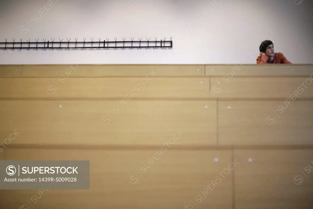Young man alone in a lecture theatre