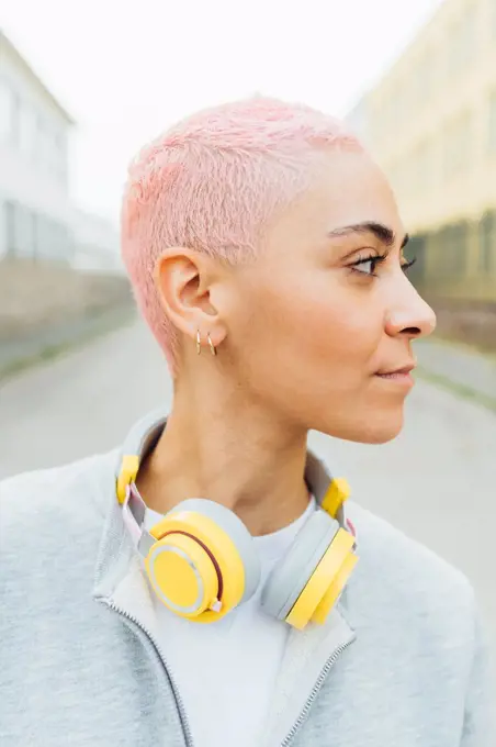 Portrait of young woman with short pink hair, wearing headphones