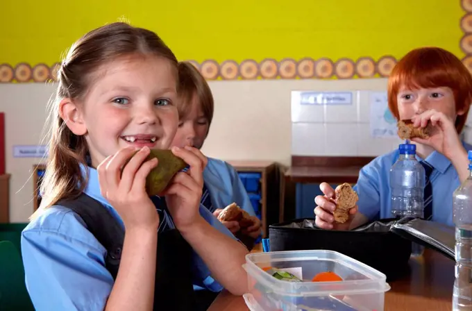 School children eating packed lunches