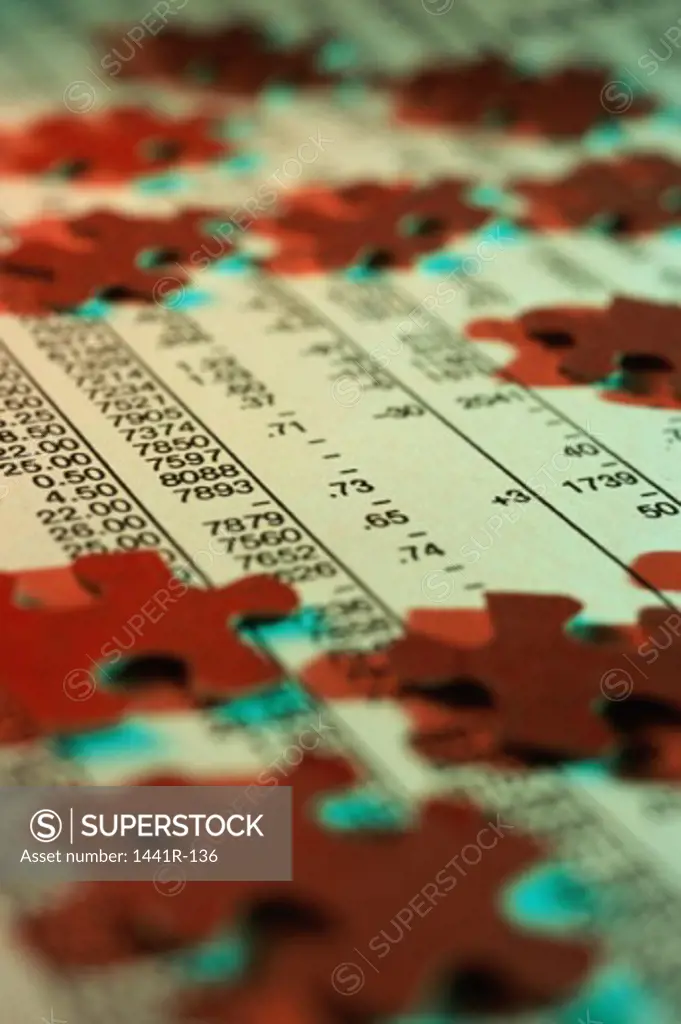 Close-up of jigsaw puzzle pieces on stock listings