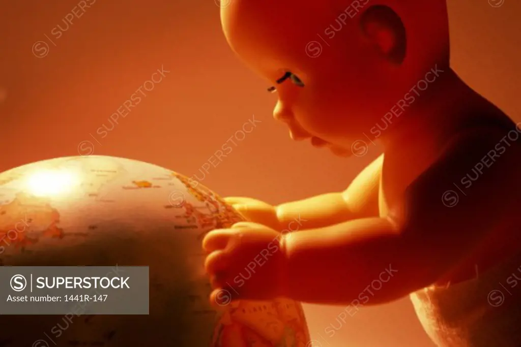 Close-up of a doll holding a globe
