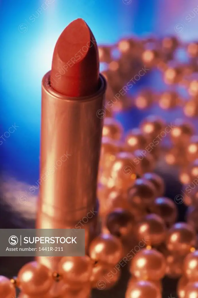 Close-up of a lipstick and pearls