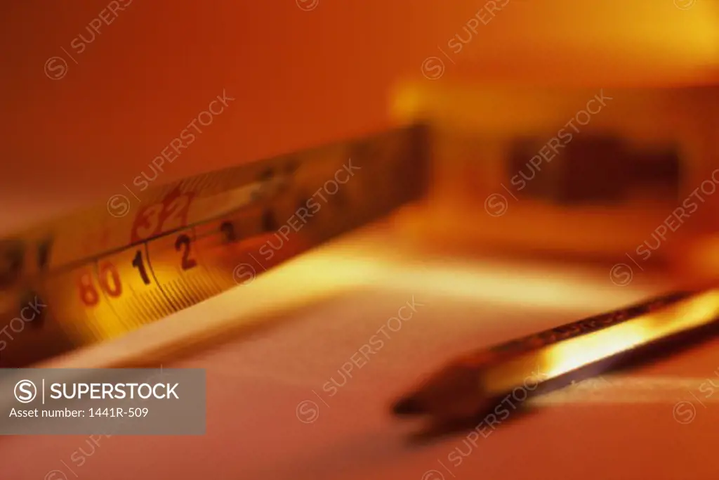 Close-up of a pencil and a measuring tape