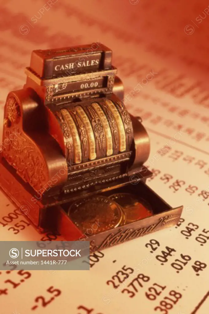 Close-up of a miniature cash register machine on stock listings