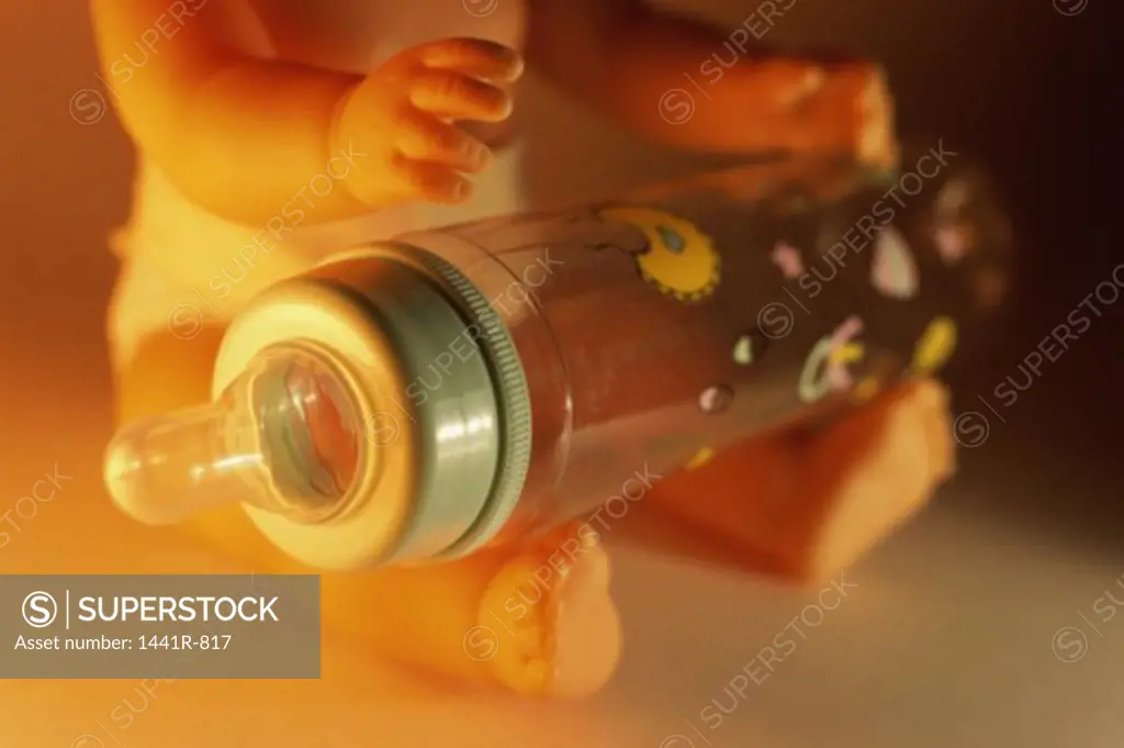 Close-up of a feeding bottle on a doll's lap