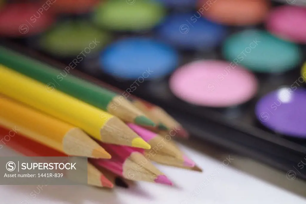 Close-up of colored pencils and a paint palette