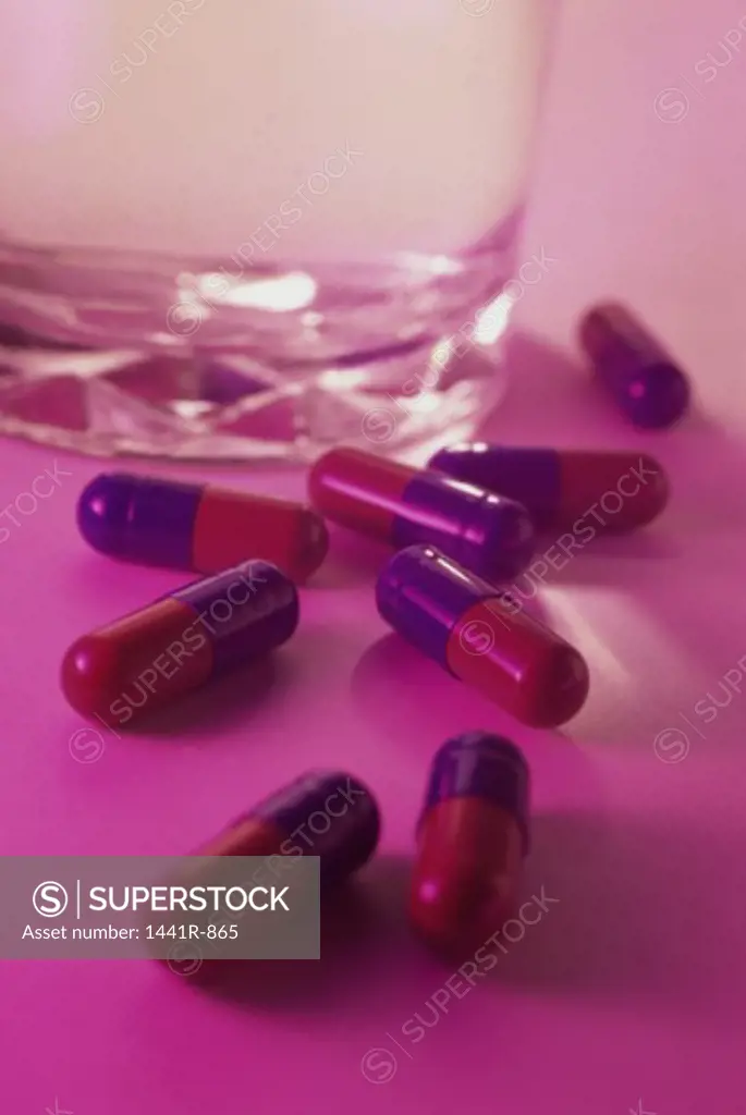 Close-up of capsules near a glass