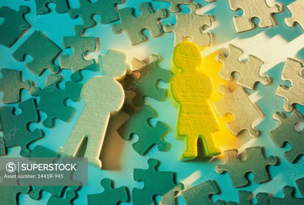 Close-up of human cutouts on jigsaw puzzle pieces