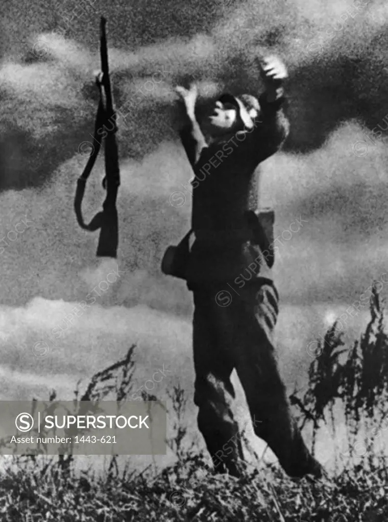 Side profile of an army soldier standing with his arms raised, 1942