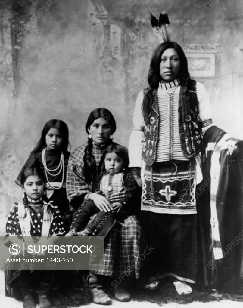 Portrait of a mid adult couple posing with their three children, 1897