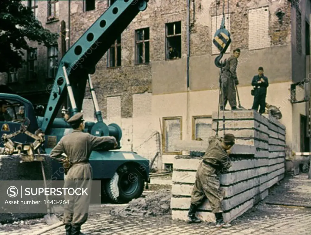 Workers constructing a wall using a crane, Berlin Wall, Berlin, Germany, 1963