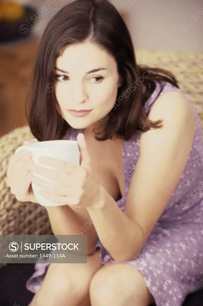 Close-up of a young woman holding a cup of coffee
