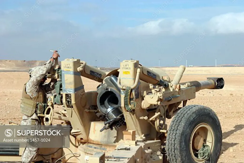 U.S. Marines with Lima Battery, 2nd Battalion, 13th Marine Regiment prepare to fire a howitzer near Baghdad, Iraq