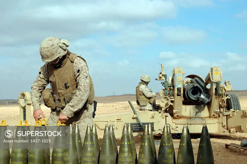 U.S. Marine with Lima Battery, 2nd Battalion, 13th Marine Regiment prepares howitzer rounds to be fired near Baghdadi, Iraq