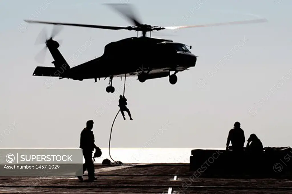 Personnel from Detachment 15, Explosive Ordnance Disposal Mobile Unit One One fast-rope out of an SH-60F Seahawk helicopter assigned to the Black Knights of Helicopter Anti-Submarine Squadron Four during an air power demonstration aboard USS Ronald Reagan