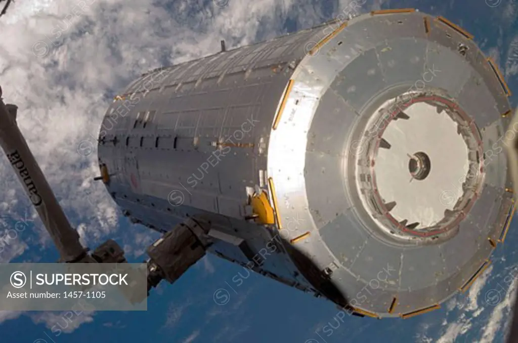 In the grasp of the station's robotic Canadarm2, the Kibo Japanese Pressurized Module (JPM) is moved from its stowage position in Space Shuttle Discovery's (STS-124) payload bay to the port side of the Harmony node of the International Space Station