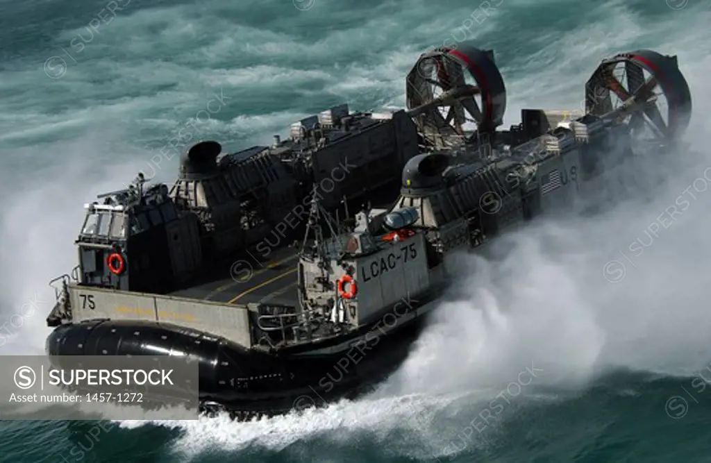 A U.S. Navy Landing Craft Air Cushion (LCAC) kicks up spray as it heads to the Kuwait Naval Base from the amphibious dock landing ship USS Harpers Ferry (LSD-49)