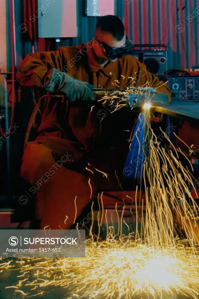 Man using an acetylene torch to cut metal