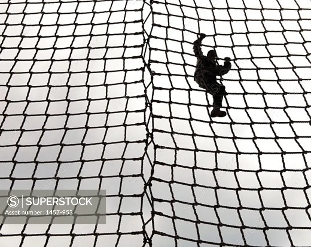 Low angle view of a soldier climbing a rope net