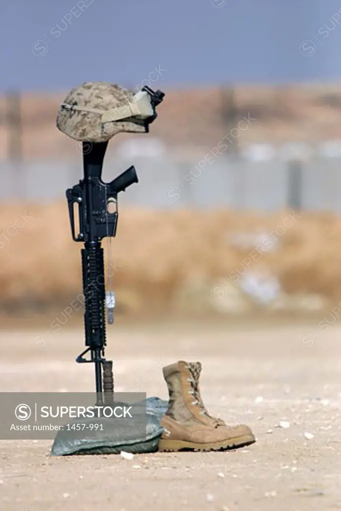 Helmet with a rifle and boots at a war memorial, Al Asad, Iraq