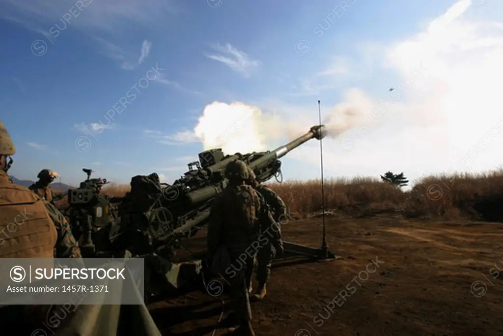 Artillerymen fire a 155mm round out of an M777 lightweight howitzer.