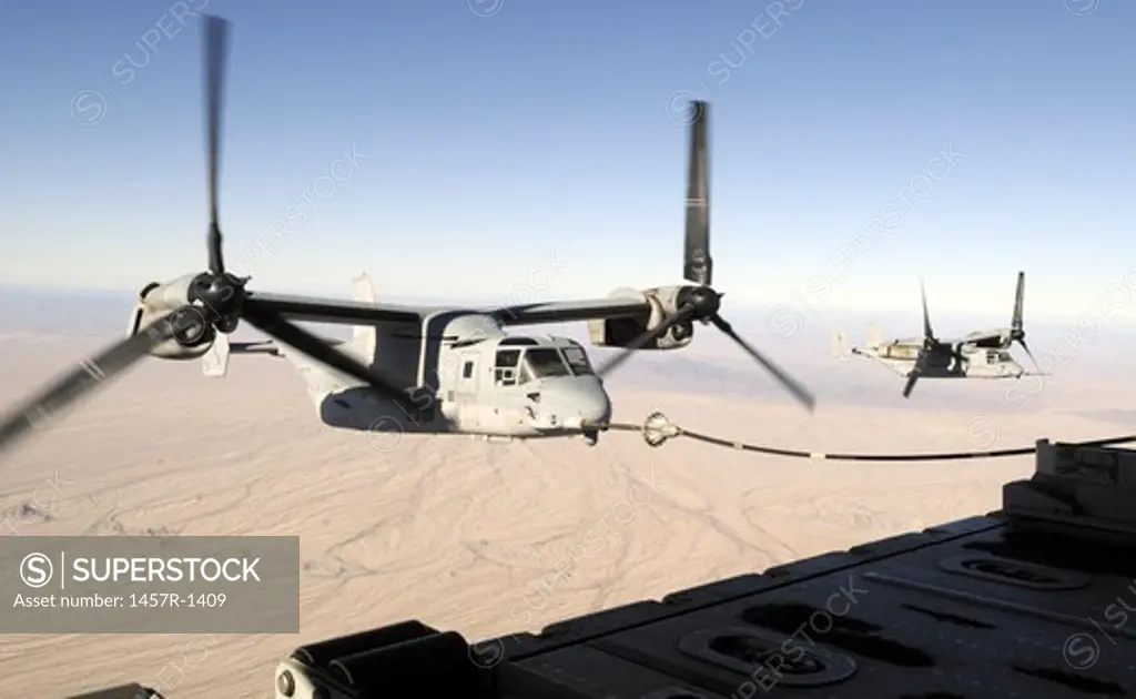 A MV-22 Osprey refuels midflight while another waits its turn.